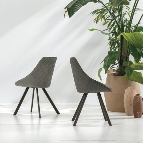 Due sedie BILBAO in tessuto grigio con gambe in legno, posizionate in un ambiente moderno con piante verdi e luce naturale.