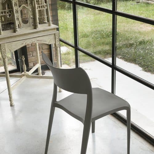 Sedia CORDOBA moderna in ambientazione luminosa con grandi vetrate e vista sul giardino, design elegante e confortevole.