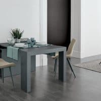 Tavolo da pranzo moderno con sedie beige in un ambiente luminoso e minimalista, decorato con piante e accessori eleganti.