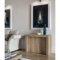 Console Pandora di 3 metri in legno naturale, decorata con oggetti di design e quadri con cavalli, in un soggiorno elegante e minimalista.