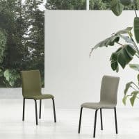 Due sedie moderne GLAMOUR NEW in tonalità verde oliva e beige, sfondo bianco e piante, stile minimalista per interni contemporanei.