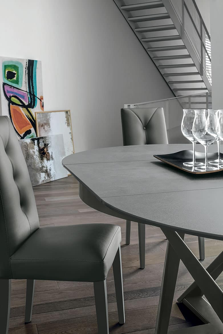 Elegante tavolo in legno grigio con sedie imbottite in stile moderno, ideale per soggiorni raffinati e ambienti contemporanei, perfetto per pranzi e cene di design.