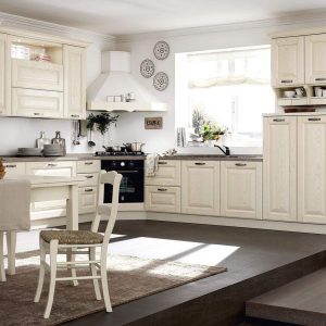 Gamma di cucine in stile classico bianco, in legno massello, con dettagli artigianali e finiture eleganti, progettata da Alpe Arredi per ambienti accoglienti e raffinati.