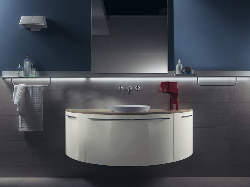 aquo_pag_210_211 Elegante lavabo sospeso con incasso, arredamento bagno moderno e specchio grande su parete blu scuro, dettagli di design e luci a LED, ideale per ambienti di alta qualità.