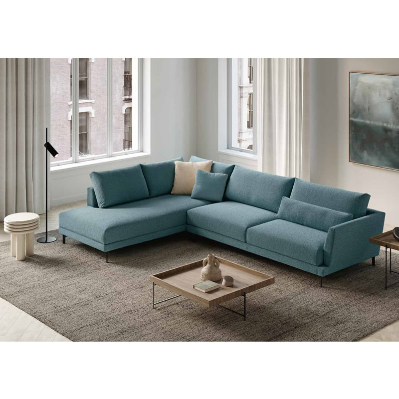 2 Elegante divano angolare in tessuto blu con cuscini coordinati in stile moderno, ideale per salotti di design, da Alpe Arredi.