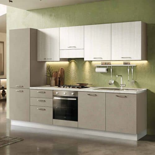Cucina moderna con ante bianche e piano in laminato chiaro, illuminata da luci sottopensile, con accessori da cucina e lavello integrato.