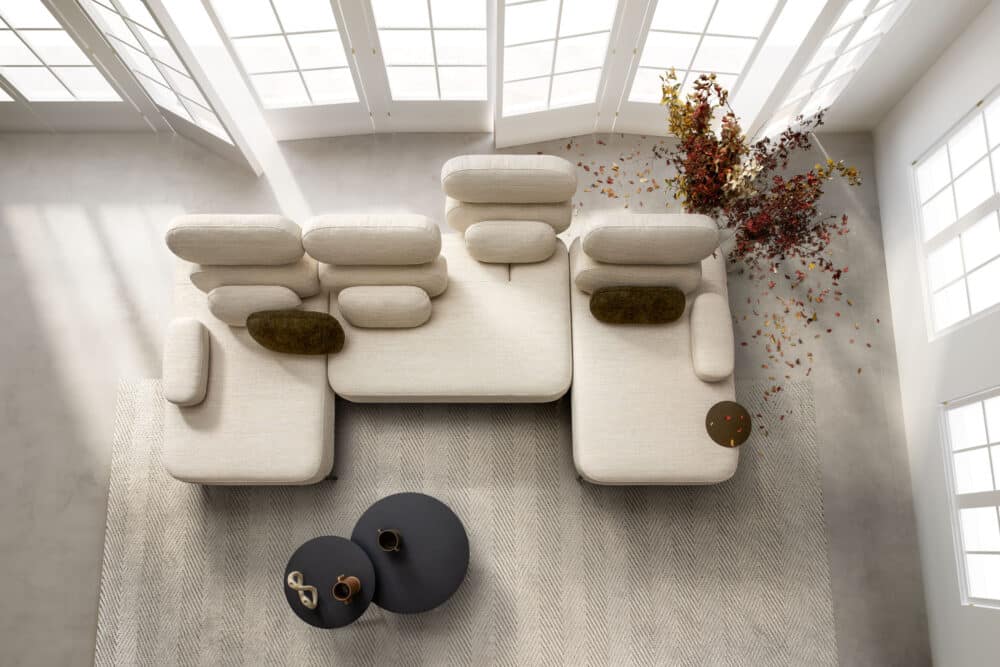 divano-avalon-collezione-divine-6-1000x667 Elegante divano modulare in tessuto beige con cuscini, ideato per ambienti moderni e raffinati, Completa il design con tavolini neri e decorazioni floreali rosse, perfetto per il soggiorno.