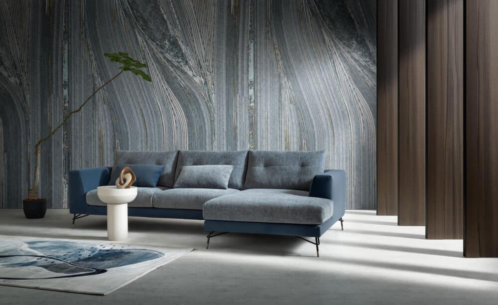 divano-dafne-collezione-experience-5-1000x612 Elegante divano moderno in tessuto grigio e blu in un soggiorno raffinato con pareti in marmo e pannelli in legno, design di alta qualità di Alpe Arredi.