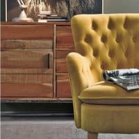 Poltrona ORLINS in tessuto giallo senape con design elegante e confortevole, ideale per ambienti moderni e raffinati.