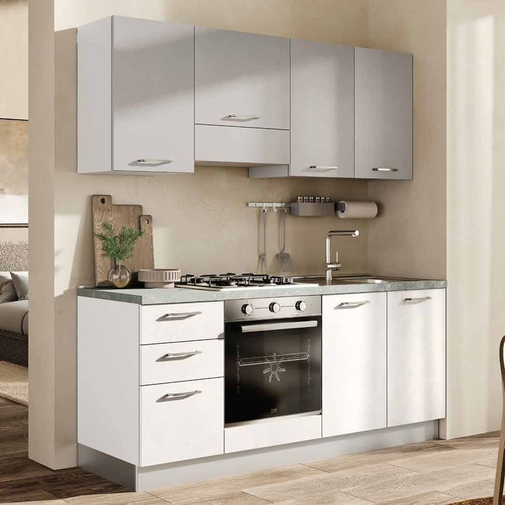 Cucina moderna compatta con ante bianche e piano in acciaio, dotata di forno e piano cottura, ideale per spazi ridotti.