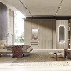 Elegante camera da letto moderna con arredi in legno chiaro, pareti grigie scure, grande finestra a parete, ramo di luce integrato, area relax con poltrona e tavolino in marmo, ideale per arredo di design.