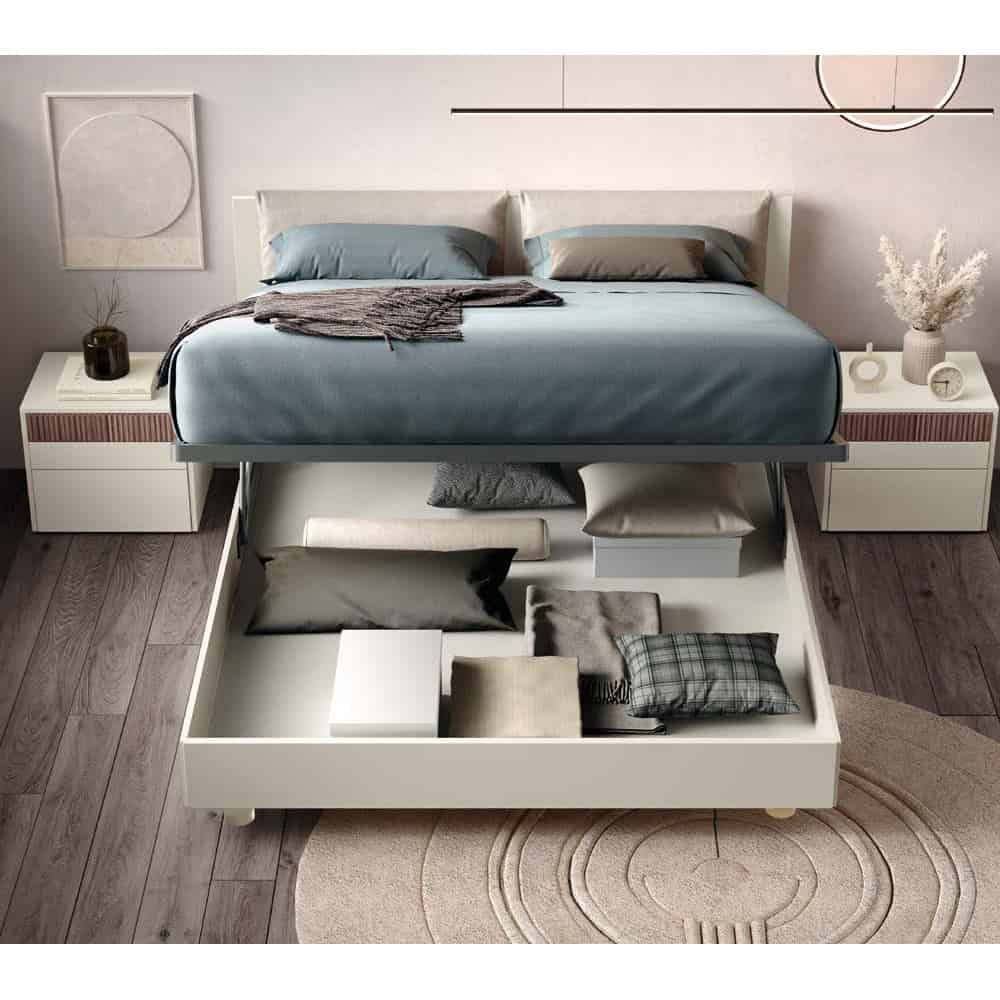 3 Cattura di un letto moderno con contenitore sotto, arredato con lenzuola blu e cuscini coordinati, in una camera elegante e minimalista con pareti neutre e decorazioni artistiche.