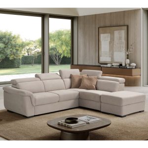Divano angolare moderno in tessuto beige in soggiorno con grandi finestre e vista sul giardino.