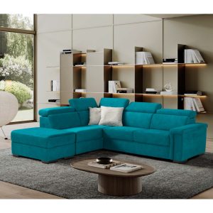 Divano angolare moderno in tessuto blu in soggiorno con libreria a parete e grande finestra con vista sul giardino.