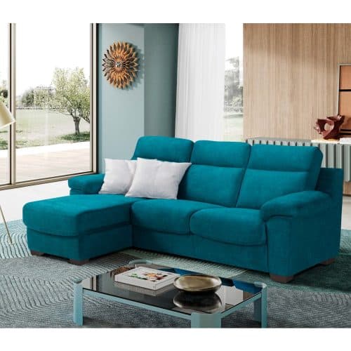 Divano con chaise longue FRANCY in tessuto blu in soggiorno moderno con grandi finestre e decorazioni eleganti.