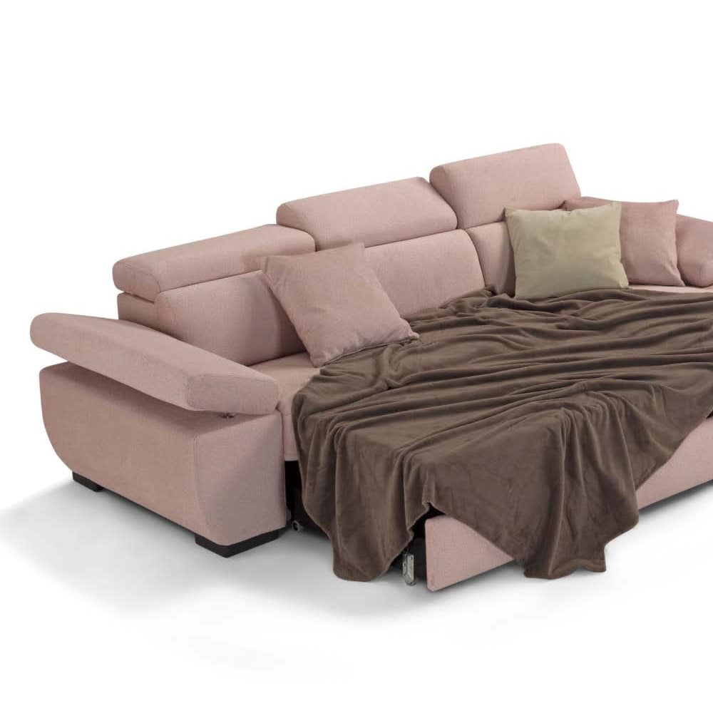 2 Divano angolare in tessuto rosa con cuscini beige e marroni, coperto da una coperta marrone, in stile moderno e confortevole.