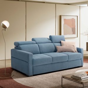 Divano moderno in tessuto blu in soggiorno elegante con pareti beige e decorazioni astratte.