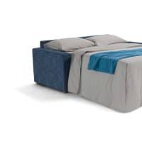 Divano letto moderno con rivestimento blu e cuscini beige, ideale per soggiorni eleganti e funzionali.