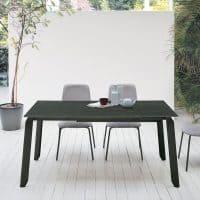 Tavolo EFESTO in legno scuro con sedie grigie in ambiente luminoso e minimalista, ideale per la zona pranzo di casa.