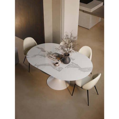 Tavolo allungabile JAZZ con piano in marmo bianco e base rotonda, circondato da quattro sedie moderne in un ambiente elegante e luminoso.