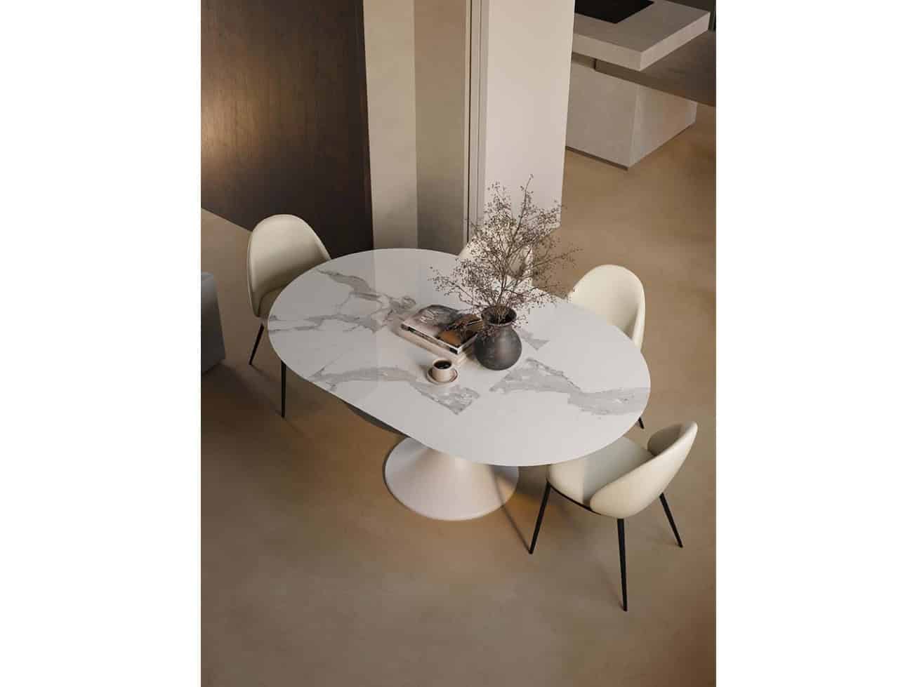 Tavolo allungabile JAZZ con piano in marmo bianco e base rotonda, circondato da quattro sedie moderne in un ambiente elegante e luminoso.