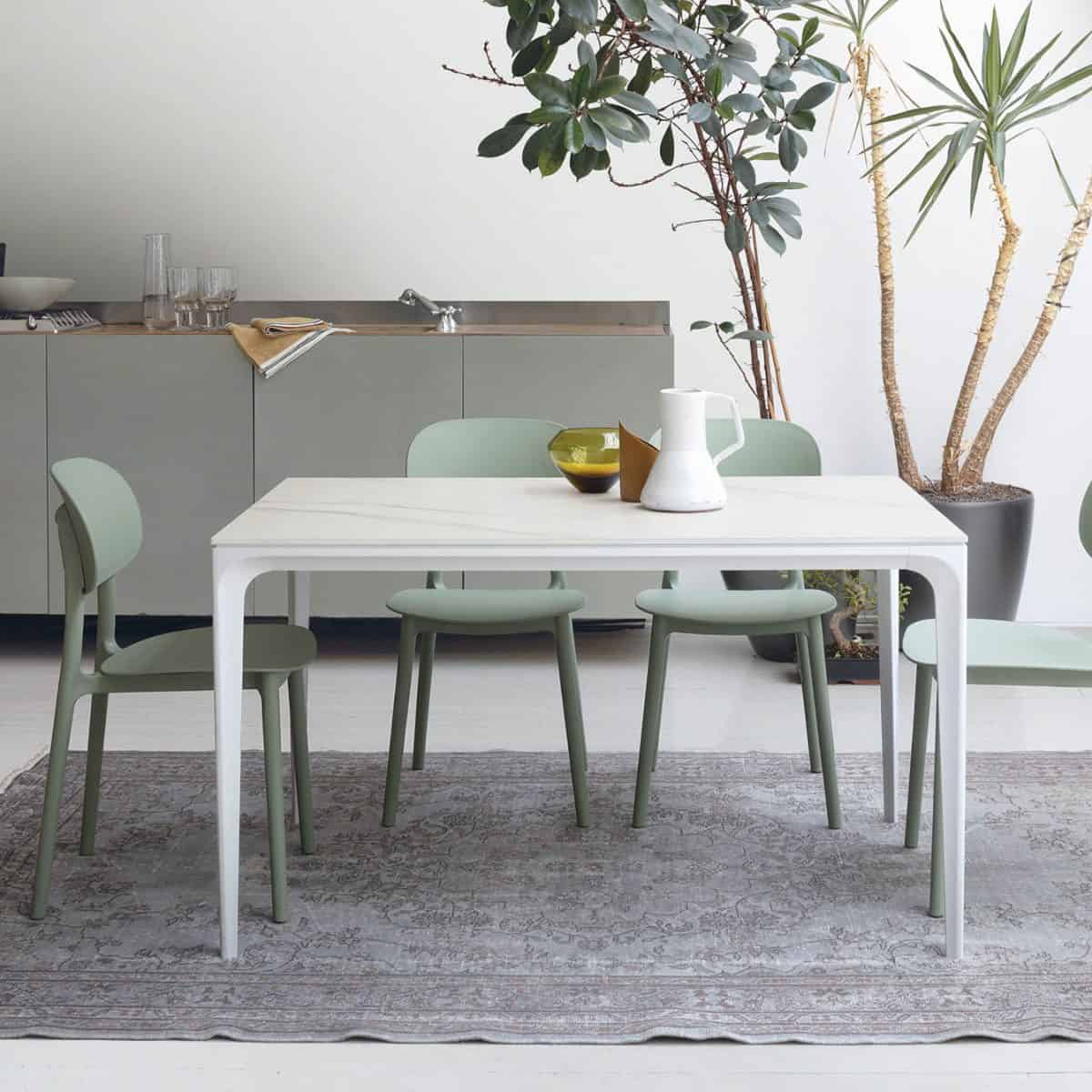Tavolo moderno Mercury di Alpe Arredi con sedie verdi in un ambiente luminoso e minimalista.