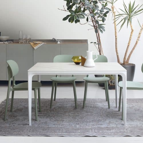 Tavolo moderno Mercury di Alpe Arredi con sedie verdi in un ambiente luminoso e minimalista.