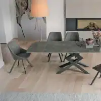 Tavolo in gress CROSS di Alpe Arredi con sedie moderne in soggiorno elegante.