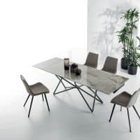 Tavolo Galaxy in marmo con sedie moderne in un ambiente luminoso e minimalista, decorato con piante verdi.