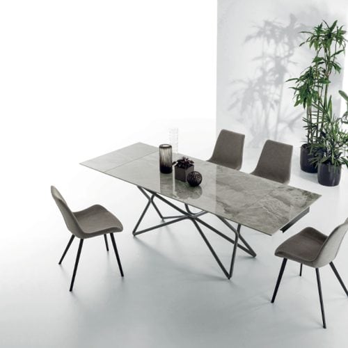 Tavolo Galaxy in marmo con sedie moderne in un ambiente luminoso e minimalista, decorato con piante verdi.