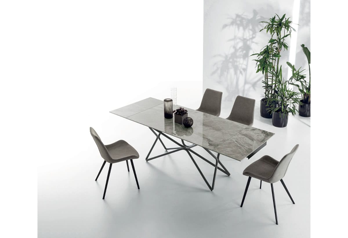 Tavolo Galaxy in marmo con sedie moderne in un ambiente luminoso e minimalista, decorato con piante verdi.