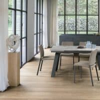 Tavolo MARTE in un ambiente luminoso con grandi finestre e sedie beige, perfetto per pranzi e incontri eleganti.