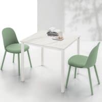 Tavolo PELLICANO con sedie verdi in un ambiente luminoso e minimalista, ideale per ambienti moderni e eleganti.