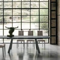 Tavolo in gres PONENTE in ambiente moderno con grandi finestre e sedie eleganti, ideale per ambienti di design contemporaneo.