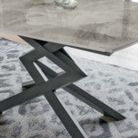 Tavolo in gress con base in metallo nero, superficie in pietra naturale, design moderno e robusto, ideale per ambienti eleganti e contemporanei.