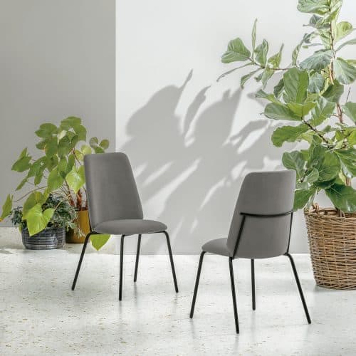 Due sedie EASY in tessuto grigio in un ambiente minimalista con piante verdi e luce naturale.