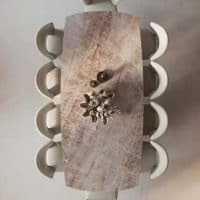 Tavolo FATUM con piano in marmo e sedie bianche, design elegante e moderno.