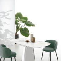 Tavolo TAY di Alpe Arredi con sedie verdi e decorazioni minimaliste in un ambiente luminoso e moderno.