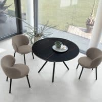 Tavolo rotondo nero con quattro sedie beige in stile moderno, ideale per ambienti eleganti e contemporanei.