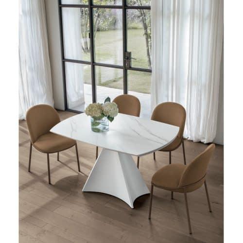 Tavolo TORNADO con sedie in tessuto beige in una stanza luminosa con grandi finestre e tende bianche, ideale per ambienti eleganti e contemporanei.